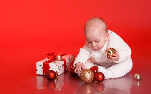 Niño jugando con decoraciones navideñas — Foto de Stock