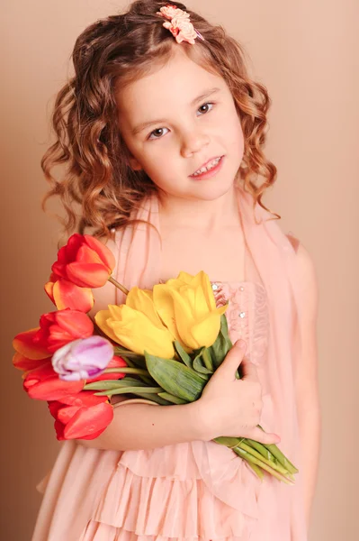 Menina segurando tulipas vermelhas — Fotografia de Stock