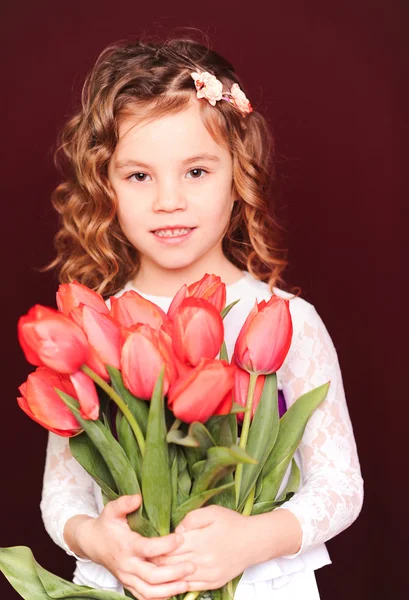 Flicka anläggning Röda tulpaner — Stockfoto