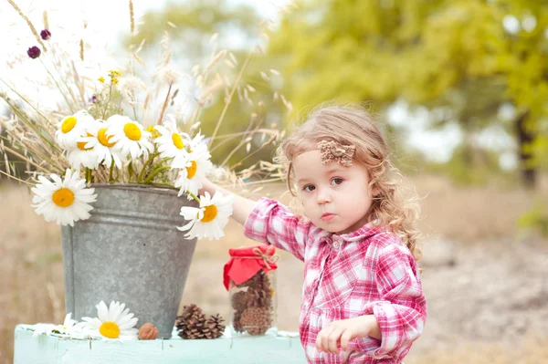 Baby flicka med kamomillblommor — Stockfoto