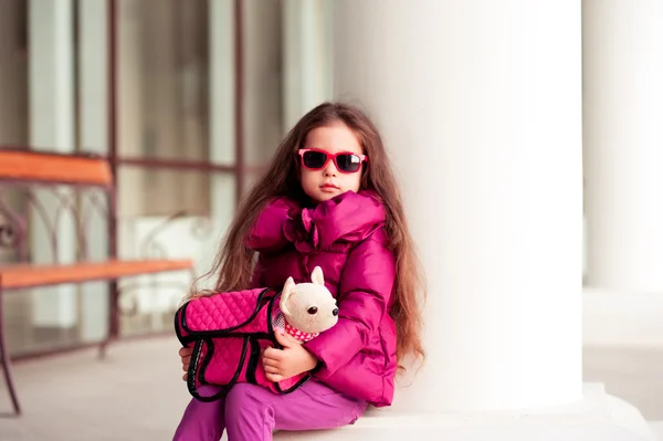 Baby girl with toy pet in bag — Stock Photo, Image