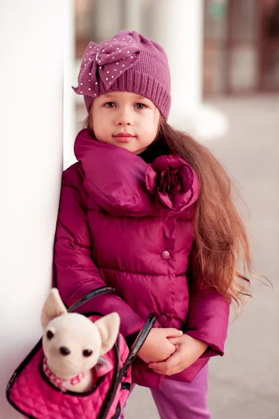 Baby girl with toy pet in bag — Stock Photo, Image