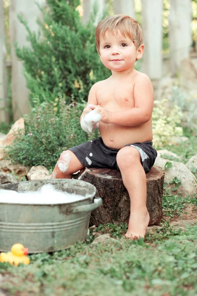 Chłopiec bawi się piany mydlanej — Zdjęcie stockowe