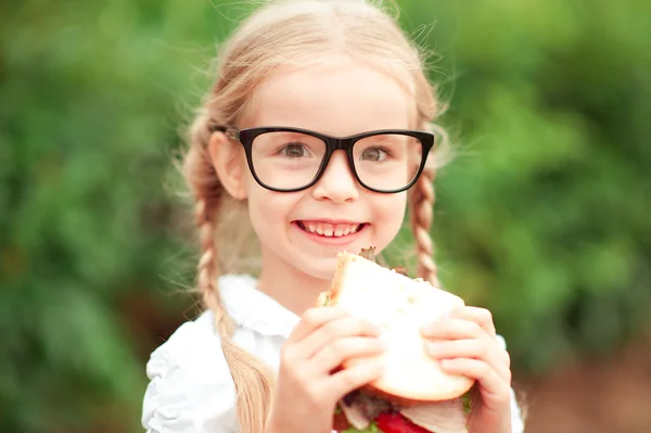 Menina aluno bonito com sanduíche — Fotografia de Stock