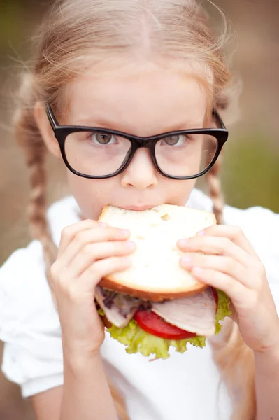 Roztomilý žák dívka s sendvič — Stock fotografie
