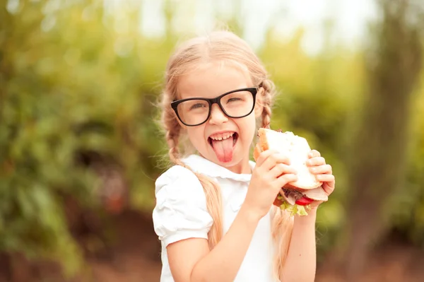 Menina aluno bonito com sanduíche — Fotografia de Stock