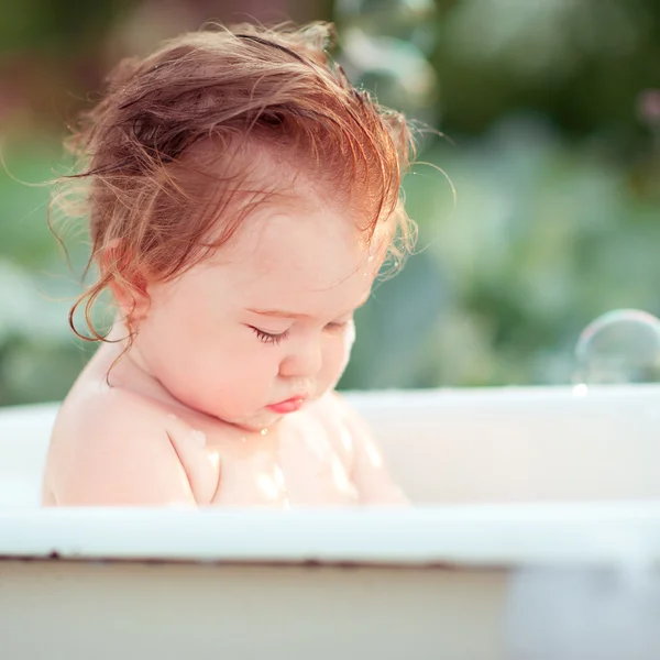 Baby flicka tvätt i badet utomhus — Stockfoto