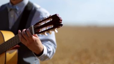 Klasik gitar çalan bir müzisyenin elleri. Bir taraftan sorunsuz bir şekilde, diğer taraftan bulanık bir şekilde odaklan. Çalarken tellerin titreşimi görülebilir. Güzel klasik gitar..