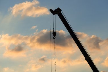 Mobil vinç çalışır durumda, gün batımında siluetleri