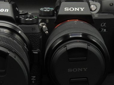 Nikon Z6, Sony A7 mark 3 ve Canon R orta bütçede ilk üçü. Nikon Z 24-70, Sony FE 28-70 ve Canon RF 24-105. Karanlık arka plan. Asıl müsabaka 2020 ve 2021..