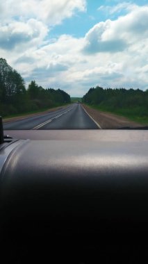 Arabanın ön camından dışarı bak. Gösterge paneli. Ön cam. Multimedya sistemi. Güneşi. Doğa.