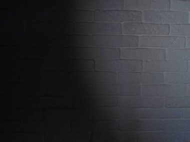 Beyaz tuğla ve desen gölgelerinden yapılmış doku duvarı. Lambanın ışığı. Arkaplan.