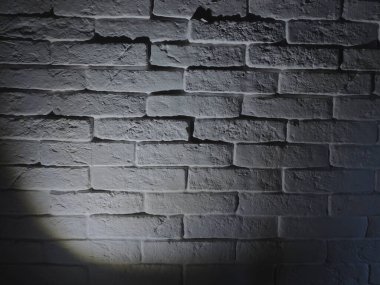 Beyaz tuğla ve desen gölgelerinden yapılmış doku duvarı. Lambanın ışığı. Arkaplan.