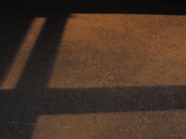 Karanlık ve dokulu duvardaki pencerenin gölgesi. Gün batımında parlak bir ışık.