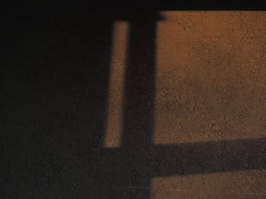 Gün batımından ve pencereden gelen desenli duvardaki gölge. Sıcak renkler. İçerde gün batımı.