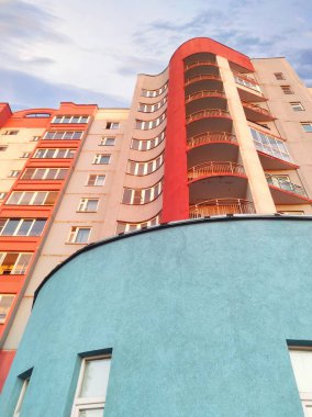 An architectural building with a rounded shape. Blue, red, and white building colors.