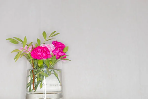 Fincanda çiçekler masanın üzerinde duruyor.