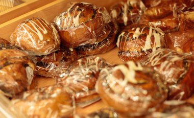 Selofan poşetlere doldurulmuş fırın ürünleri tepside duruyor, yakın plan.