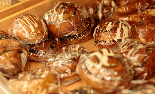 Selofan poşetlere doldurulmuş fırın ürünleri tepside duruyor, yakın plan.