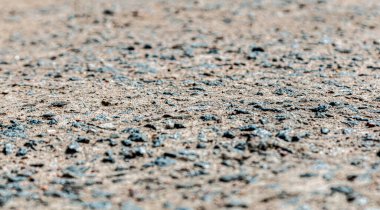 Gri kumdaki siyah taş, asfalt