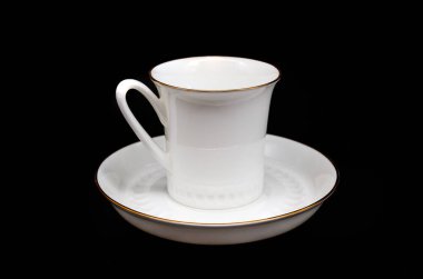 Siyah arka planda kahve için beyaz fincan ve fincan tabağı yakın plan.