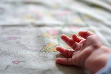 Bebek bezi arkaplanındaki bebek eli.