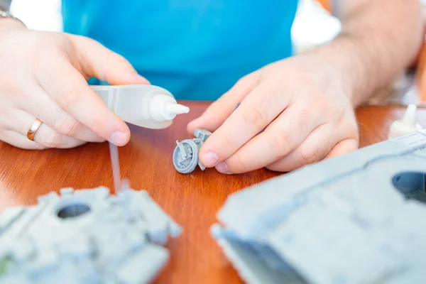 Seorang Pria Merakit Model Tangki Mainan Dari Plastik Menempelkan Menetas Stok Gambar