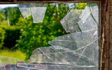 Binanın içinde kırık camlar, güneşli bir gün.