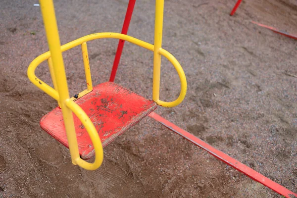 child\'s metal swing on the street close up