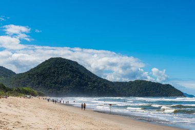 Brezilya 'da dağların arasında tropikal sahilde yürüyen turistler