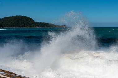 Brezilya sahilinde kayalara vuran beyaz bir dalga köpüğü.