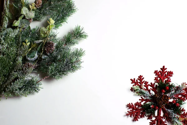 コーンと赤い果実と赤い雪の結晶と装飾的な緑の霜松の枝 クリスマスと新年の組成物 白い背景 コピースペース — ストック写真