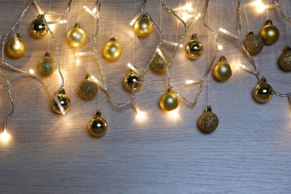 Χρυσές Χριστουγεννιάτικες Μπάλες Κρέμονται Κλωστές Και Γιρλάντα Από Χριστουγεννιάτικα Φώτα — Φωτογραφία Αρχείου