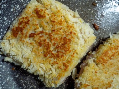 Çıtır ekmekli şnitzeller tavada kızartılır. Yağ tavanın yüzeyinde parlıyor. Yemek arkaplanı ve iştah açıcı pirzola..