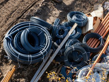 Electrical work on the laying of electrical cables. Rolls of cables and plastic pipes prepared for installation work.
