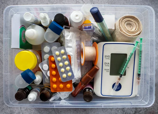 First aid kit with medicines, tonometer, thermometers, dressings, syringes, inhalers and medical supplies. Medical background with medicines and products for the prevention and treatment of diseases.