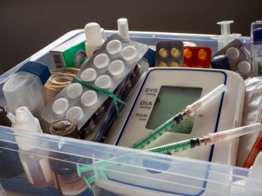 İlaçlı ilk yardım çantası. Tonometre, şırıngalar, tabletler ve diğer tıbbi cihazlar plastik bir kutuya konur. İlk yardım çantasıyla tıbbi geçmiş.