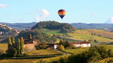 Sıcak hava balonu, Barolo, Alba, Langhe, Piedmont, İtalya 'daki sonbahar renkleriyle tepeler arasında Kasa' nın üzerinde uçuyor.