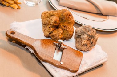 Tahta dilimleyicide iki büyük beyaz yer mantarı ve yıldızlı restoran masasında beyaz peçete.