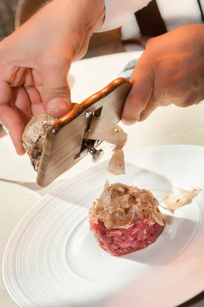 Alba white truffle sliced by the waiter\'s hands on raw minced meat from Piedmontese beef of the Fassona breed