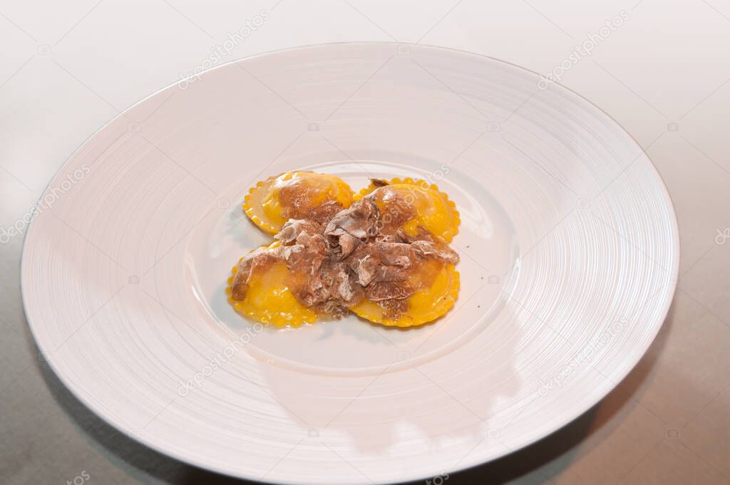 Alba white truffle sliced on Italian egg pasta ravioli, italian gourmet dish