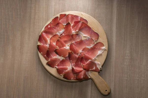 Speck, Güney Tyrol 'dan tipik tütsülenmiş jambon, İtalya' dan Alto Adige - tahta kesme tahtasındaki dilimler.