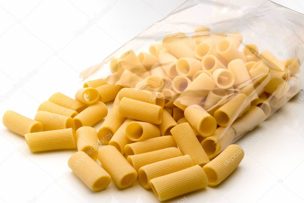 Paccheri macaroni Italian dry raw pasta bronze drawn, rough paste from Gragnano,Naples,Italy, in transparent packaging on white background