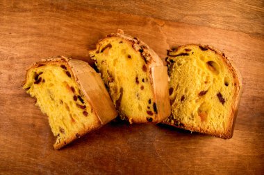 Panettone, Milan 'dan klasik Noel pastası, üç dilim sade ahşap arka planda izole edilmiş