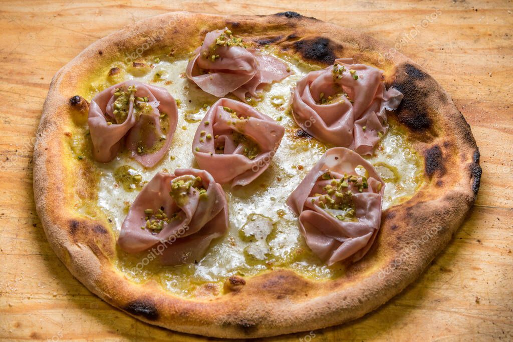 pizza con queso, salami de mortadela de Bolonia y pistachos picados