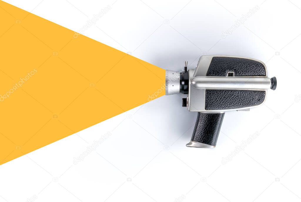 old style movie camera that simulates shooting with abstract yellow light cone that starts from the lens, on a white background