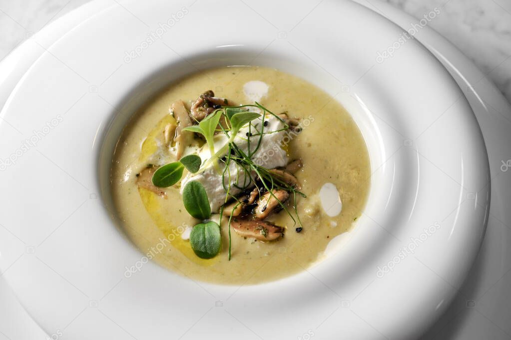 Artichoke cream with mushrooms and cheese mousse, with green sprouts in white plate, top view