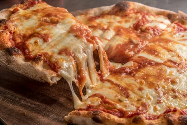 Domatesli bir dilim pizza ve erimiş sıcak mozzarella.