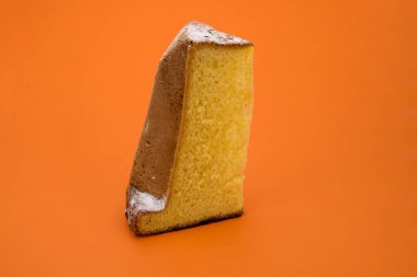 Pandoro, tipik İtalyan Noel tatlısı, krema şekerli bir dilim izole edilmiş turuncu arka plan.
