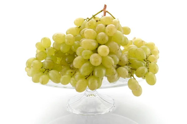 白色桌上的葡萄 意大利乌娃的一束 放在独立于白色背景的凸起的玻璃器皿上 — 图库照片